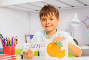 Positive boy in development class with word and object card during ABA therapy